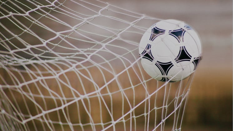 Fußball in einem Tornetz - Sinnbild für Zielerreichung im B2B Marketing