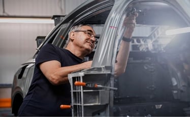 Eine Person arbeitet an einem Fahrzeug.