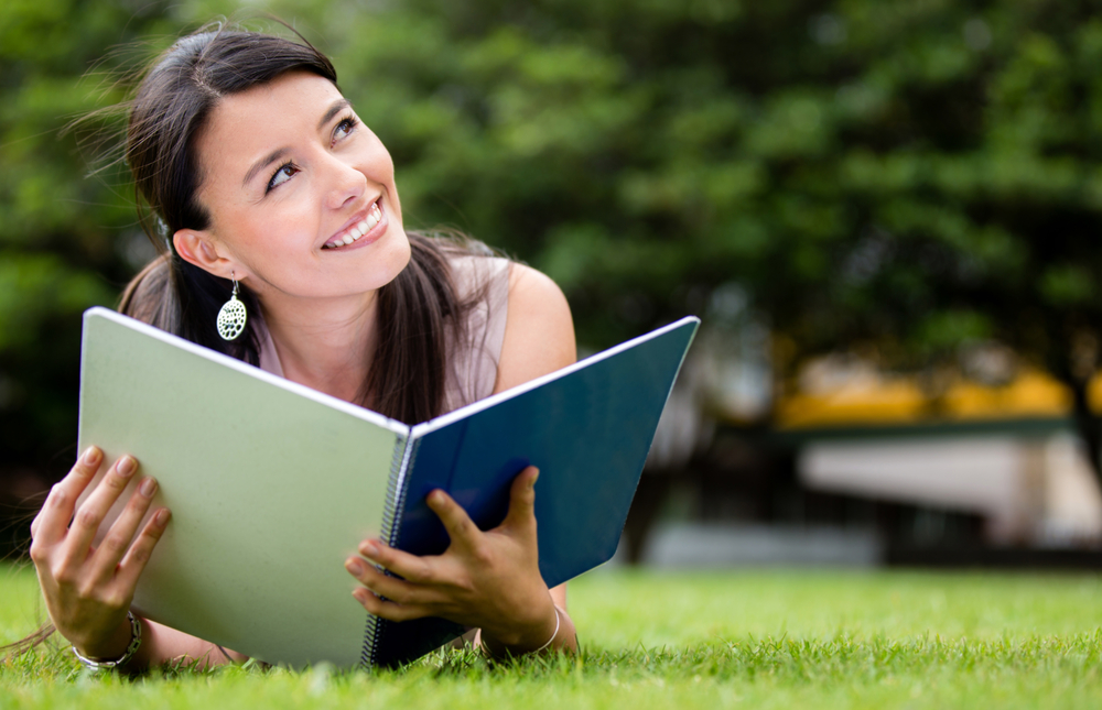 Thoughtful female student lying at the park Thoughtful female student lying at the park