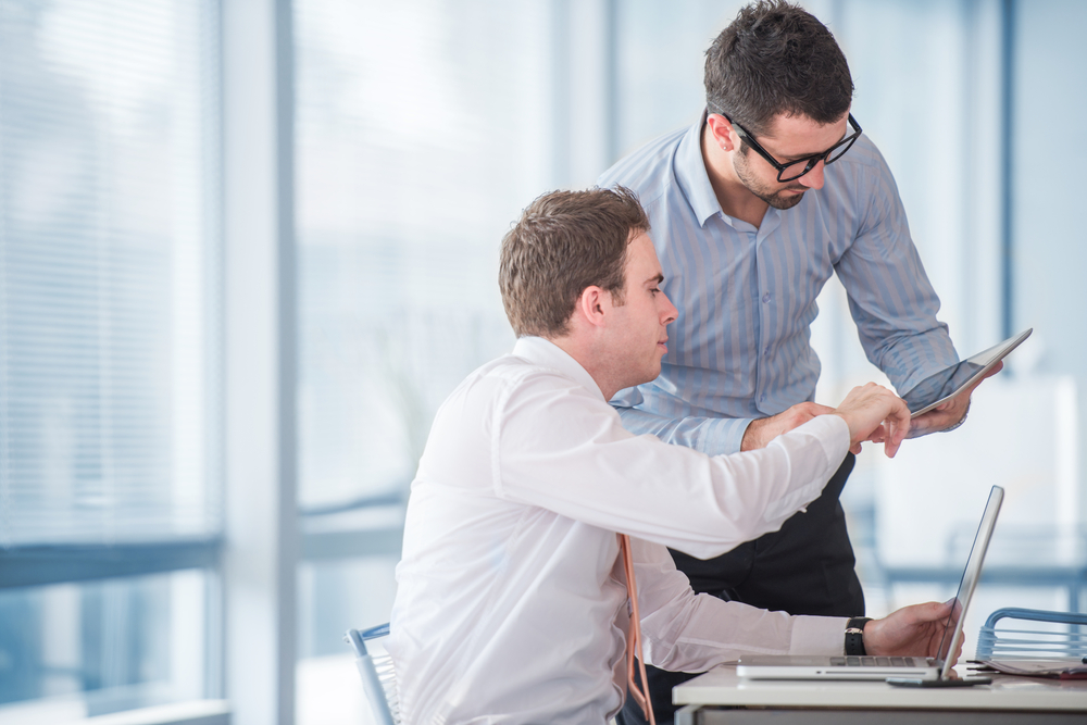 Two businessmen at work with a tablet in office Two businessmen at work with a tablet in office
